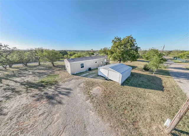 a view of a dry yard with wooden fence