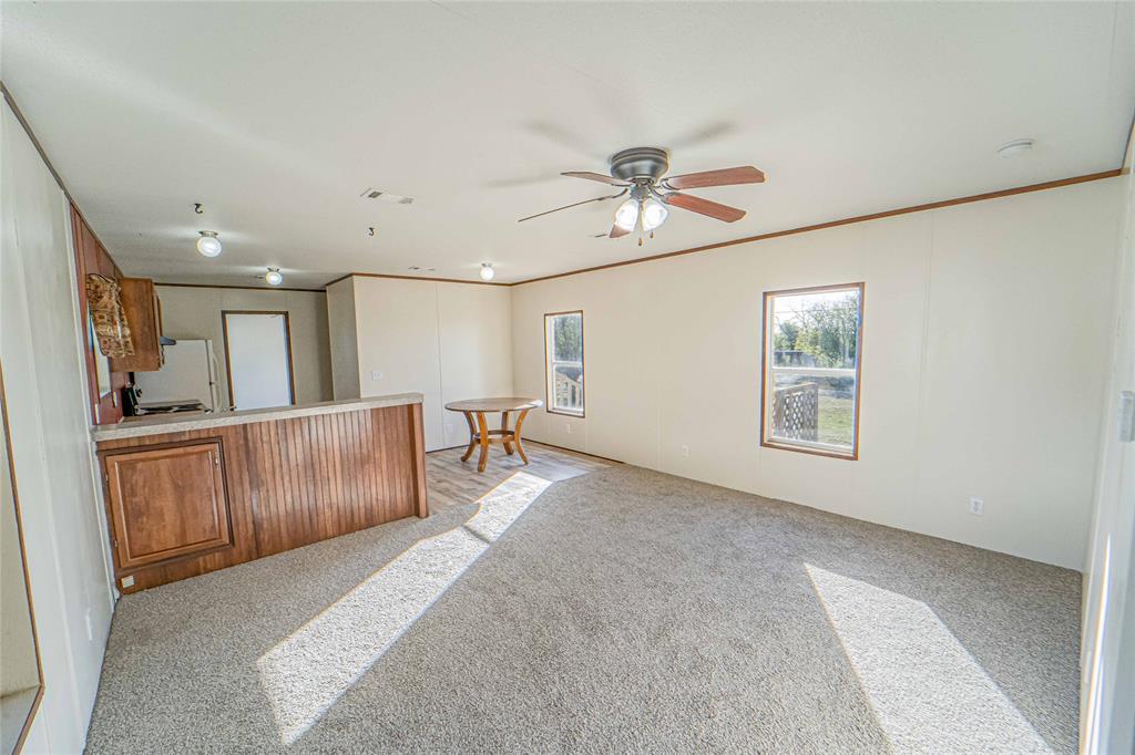 605 South Butte Street Breckenridge, TX 76424 - Photo 8 of 26 a view of a livingroom with furniture a ceiling fan and wooden floor