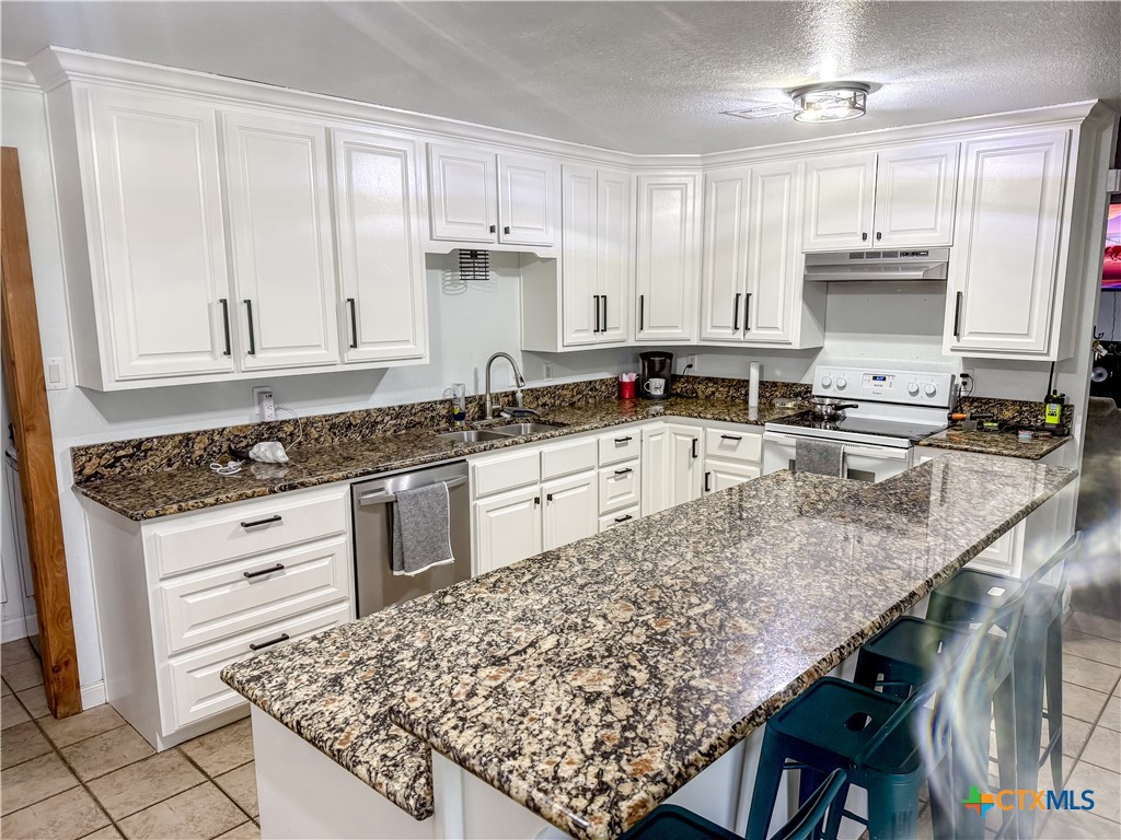 508 Straws Mill Road Gatesville, TX 76528 - Photo 5 of 26 a kitchen with stainless steel appliances granite countertop a sink stove and cabinets