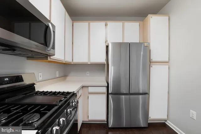 a kitchen with a refrigerator and a stove top oven