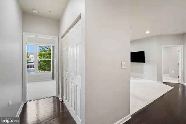 a view of a hallway with wooden floor and windows