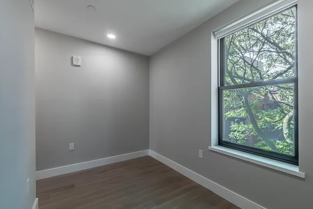 a view of a hallway with stairs and wooden floor