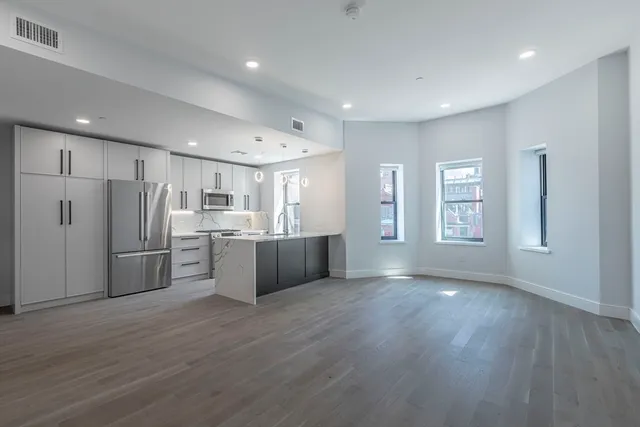 a view of kitchen with wooden floor and electronic appliances