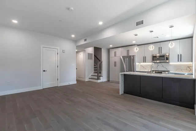 a view of kitchen with refrigerator sink and wooden floor