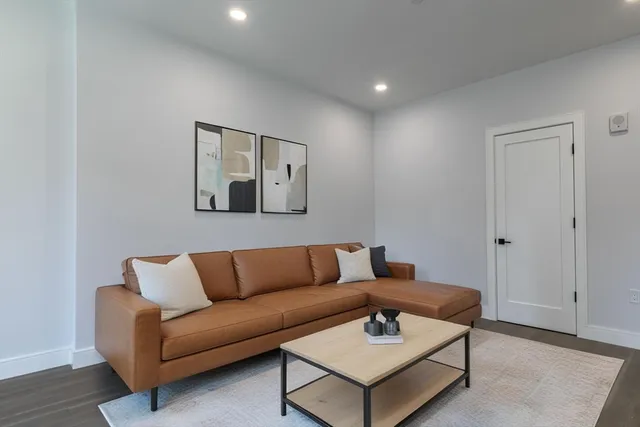a living room with furniture and a wooden floor