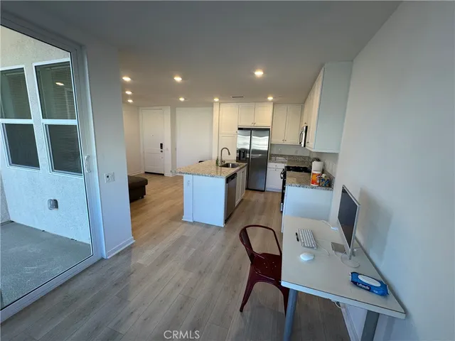 a kitchen with stainless steel appliances granite countertop a sink a stove and a wooden floors