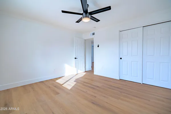 a view of empty room with wooden floor
