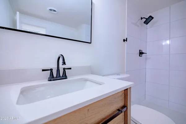 a bathroom with a sink a toilet and a mirror