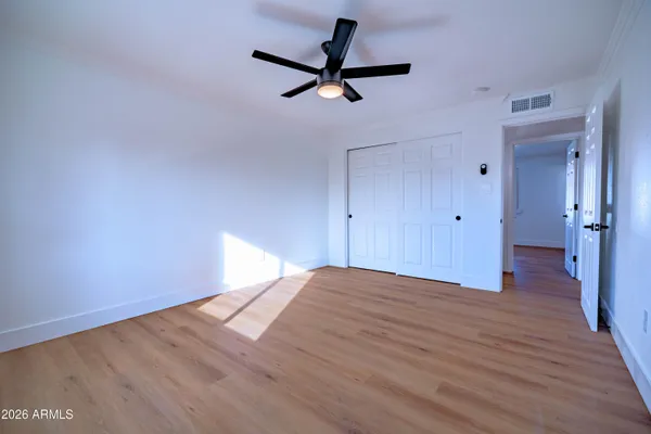 a view of a room with wooden floor and a ceiling fan