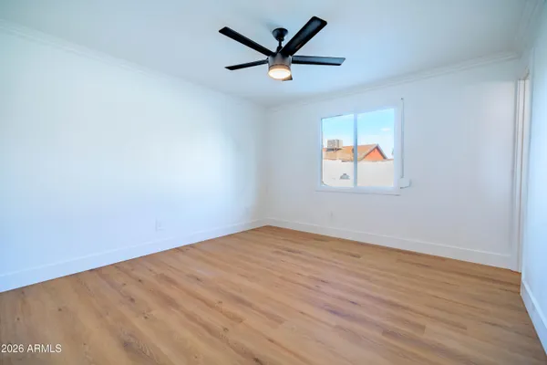 a view of an empty room with window and wooden floor