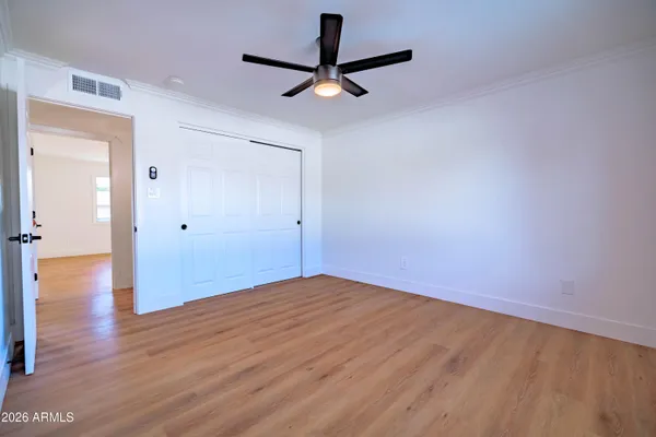 a view of a room with wooden floor and a ceiling fan