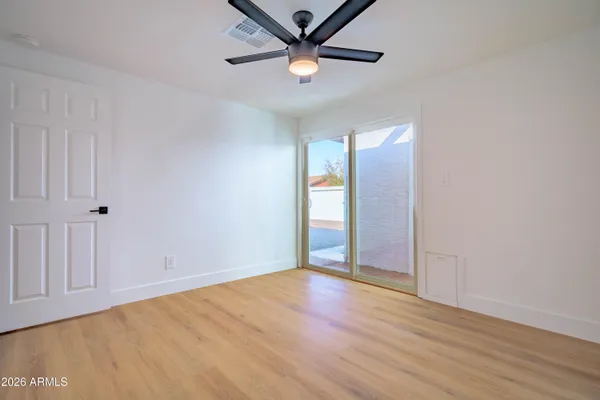 an empty room with wooden floor and windows