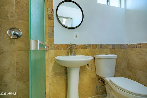 a bathroom with a toilet a sink and a mirror