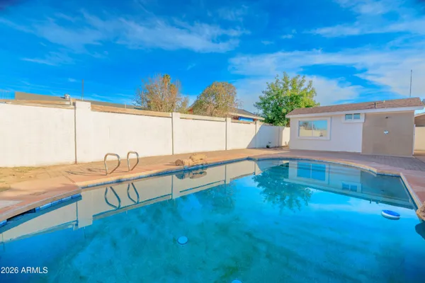 a view of a swimming pool with a chair and tables