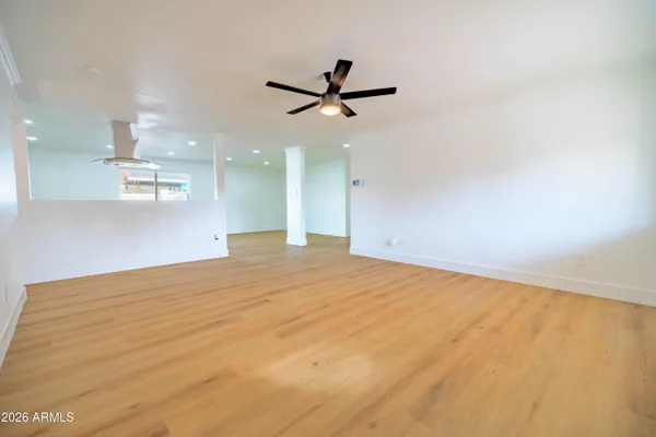 a view of a big room with wooden floor and a ceiling fan