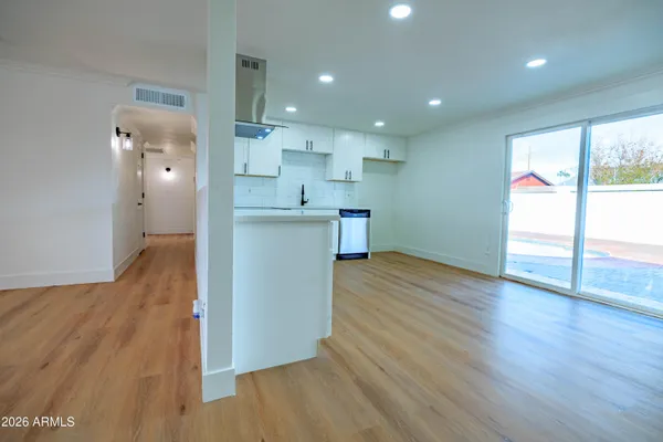 a view of a kitchen with wooden floor and a window