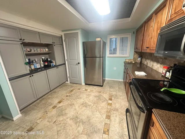 a kitchen with stainless steel appliances granite countertop a refrigerator and a stove top oven