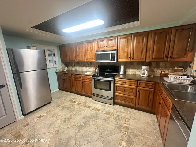 a kitchen with stainless steel appliances granite countertop a refrigerator stove top oven and sink