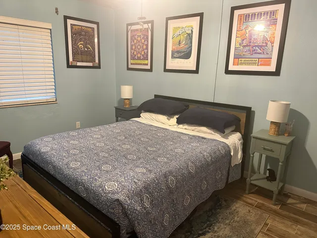 a bedroom with a bed and wooden floor