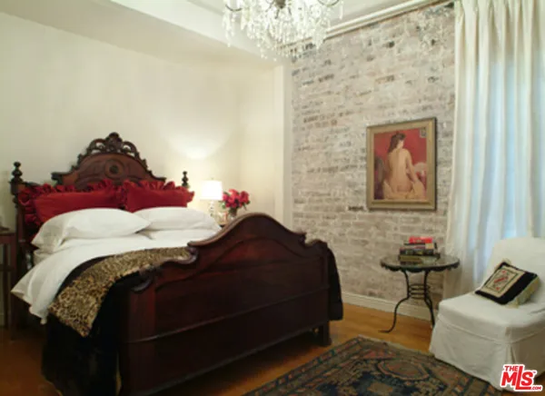 a bedroom with a bed and a chandelier