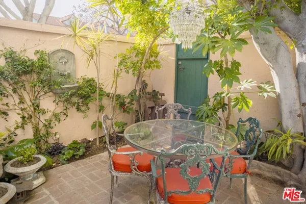a backyard with table and chairs potted plants