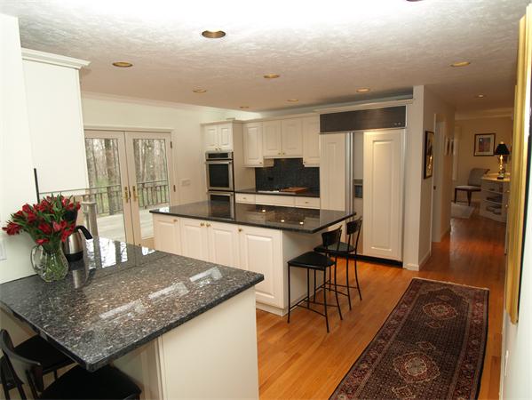 108 West Berlin Road Bolton, MA 01740 - Photo 5 of 25 a kitchen with stainless steel appliances granite countertop a stove top oven a sink a dining table and chairs with wooden floor