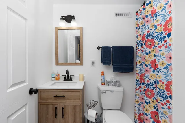 a bathroom with a sink toilet and a mirror