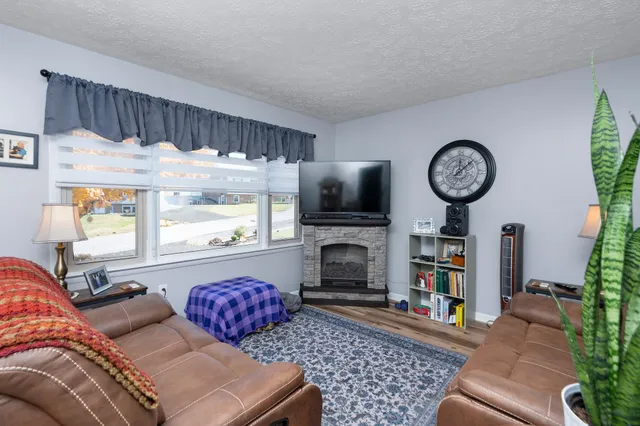 a living room with furniture a flat screen tv and a fireplace