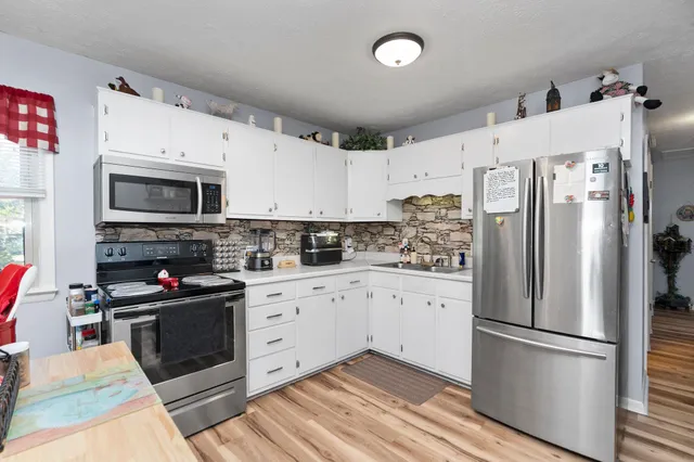a kitchen with stainless steel appliances a refrigerator sink and microwave