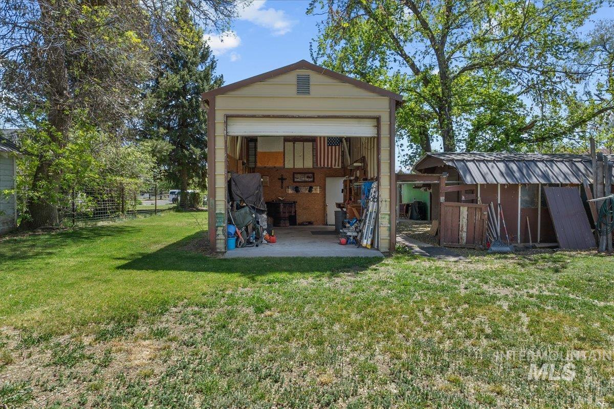 1958 East 1775 South Gooding, ID 83330 - Photo 46 of 49 Detached garage structure with a roll-up door, concrete flooring, and interior shelving