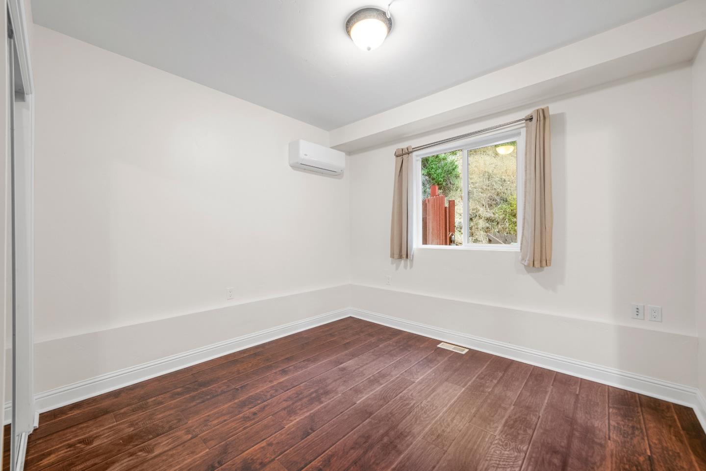 Undisclosed Address Boulder Creek, CA 95006 - Photo 34 of 41 an empty room with wooden floor and windows