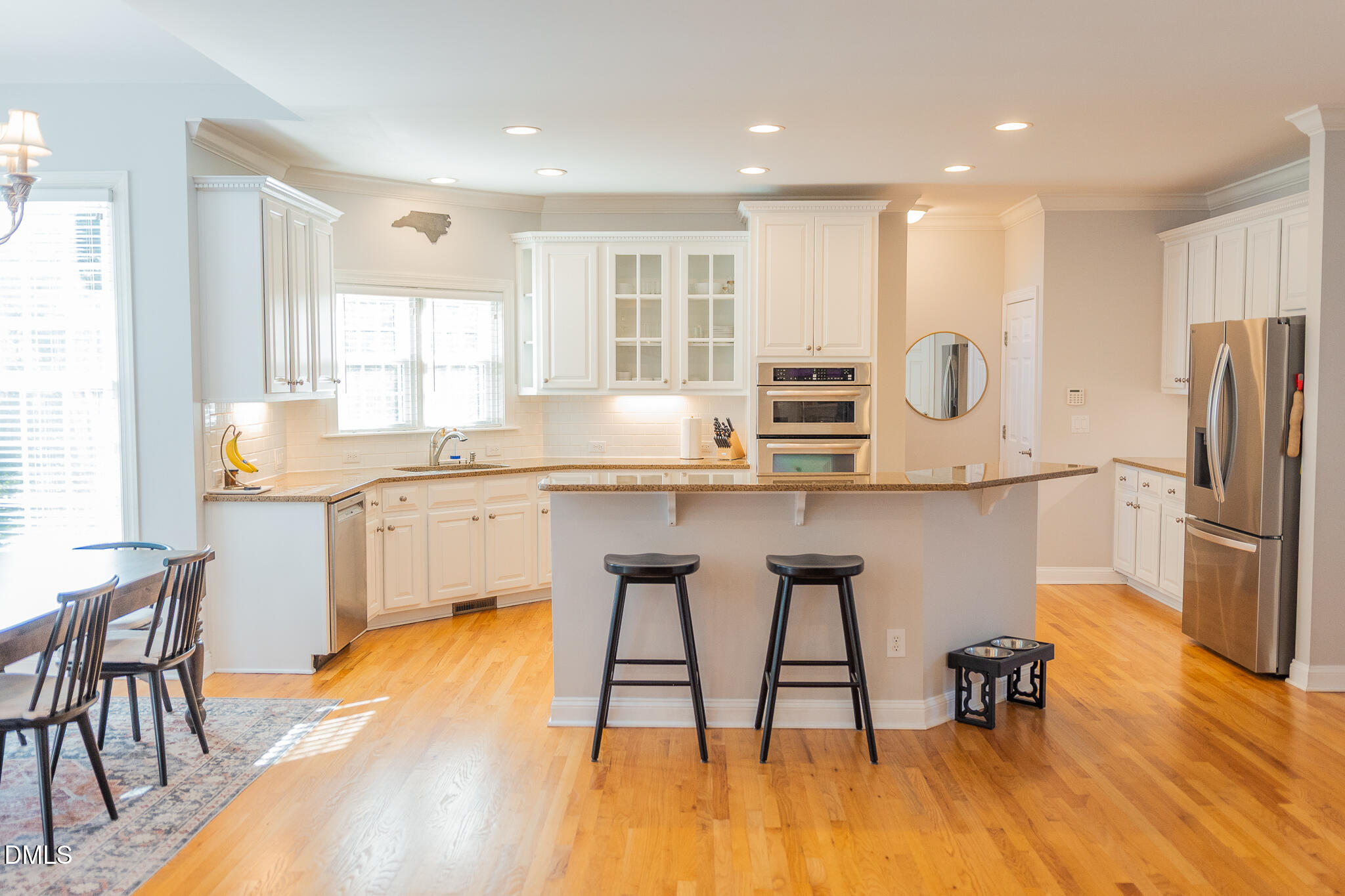 12324 Canolder Street Raleigh, NC 27614 - Photo 7 of 64 a kitchen with stainless steel appliances granite countertop a table chairs refrigerator a sink and dishwasher with wooden floor