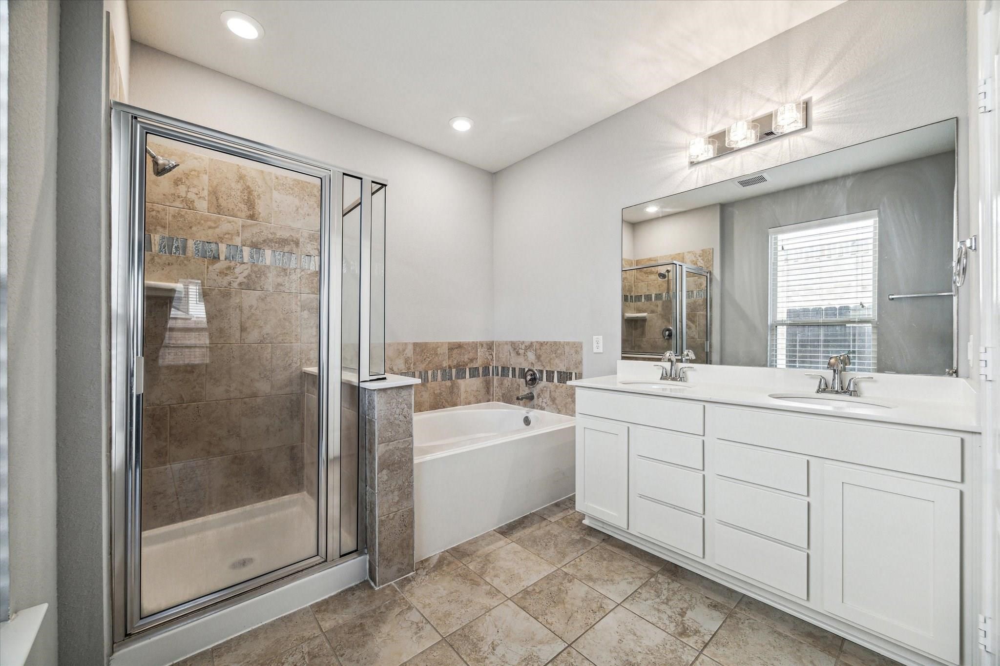 14019 Harmony Ridge Trail Pearland, TX 77584 - Photo 4 of 10 a spacious bathroom with a double vanity sink a large mirror and shower