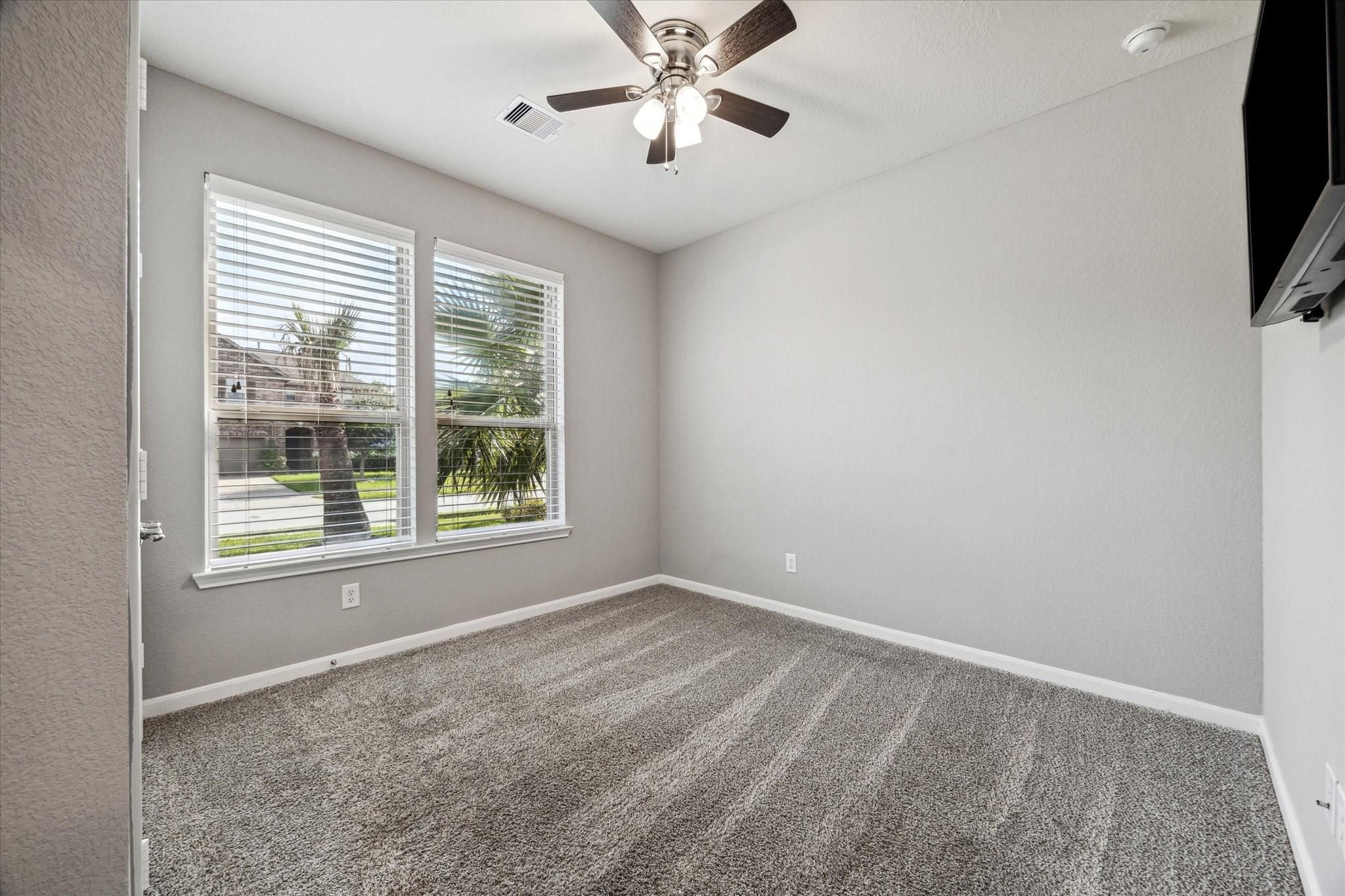 14019 Harmony Ridge Trail Pearland, TX 77584 - Photo 5 of 10 a view of an empty room with window and a ceiling fan
