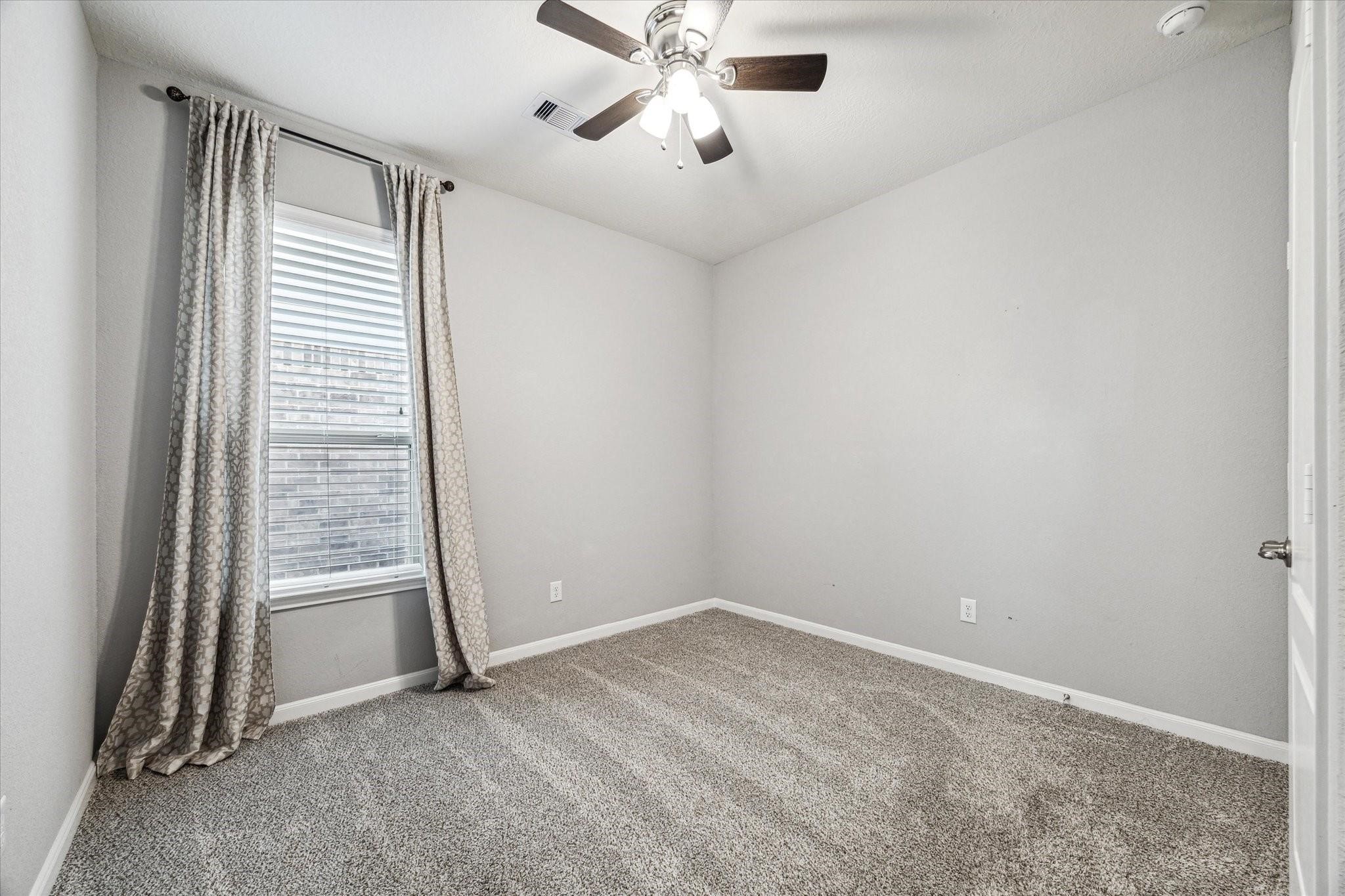 14019 Harmony Ridge Trail Pearland, TX 77584 - Photo 6 of 10 an empty room with closet and windows