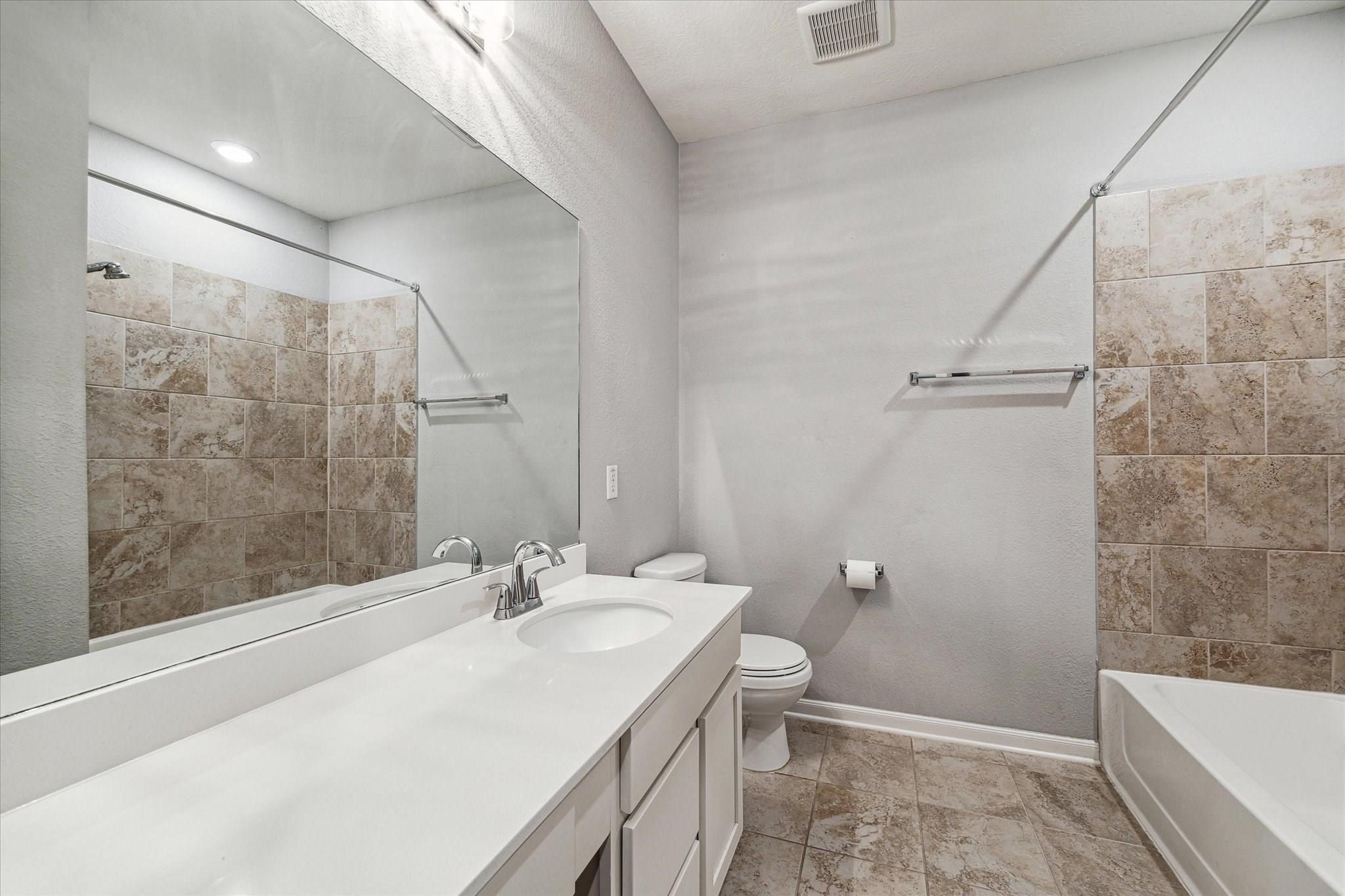 14019 Harmony Ridge Trail Pearland, TX 77584 - Photo 7 of 10 a bathroom with a granite countertop sink a toilet and shower