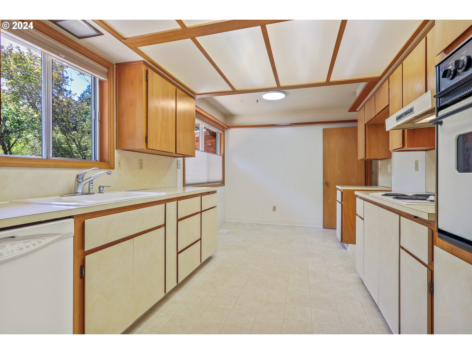 7130 Southwest Locust Street Portland, OR 97223 - Photo 4 of 28 a kitchen with stainless steel appliances sink refrigerator and window