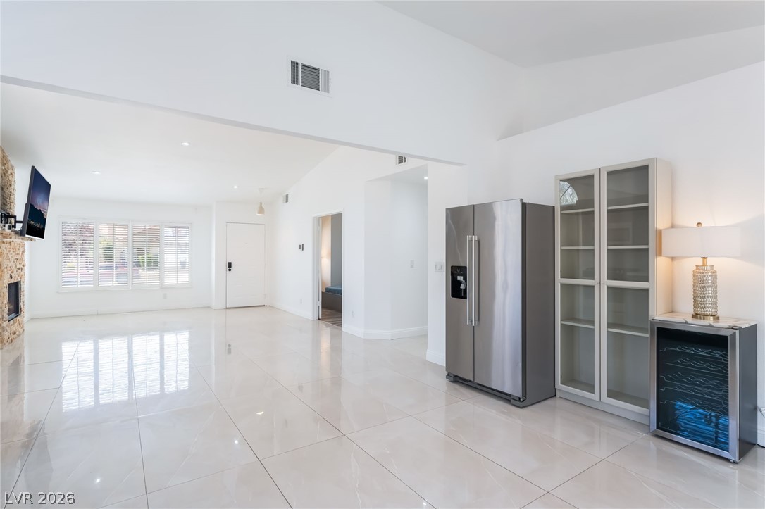 9028 Cypress Point Road Las Vegas, NV 89117 - Photo 39 of 39 Bright interior features an inviting open floorplan with a prominent fireplace and sleek tile flooring.