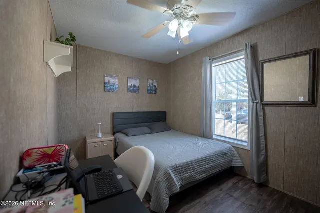 a bedroom with a bed and wooden floor