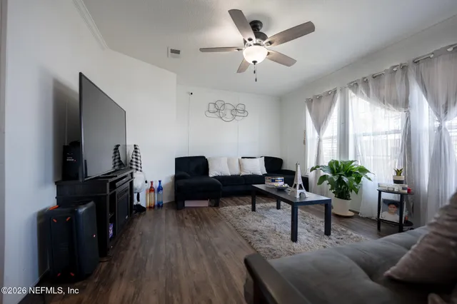 a living room with furniture a fireplace a flat screen tv and a large window