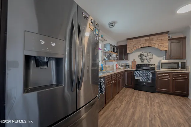 a kitchen with stainless steel appliances granite countertop a refrigerator a stove a sink and dishwasher