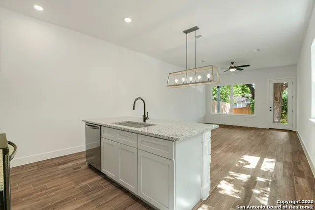 a kitchen with stainless steel appliances granite countertop a sink a stove and a refrigerator