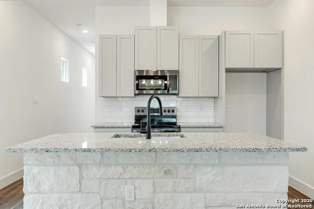 a kitchen with granite countertop a stove and a sink