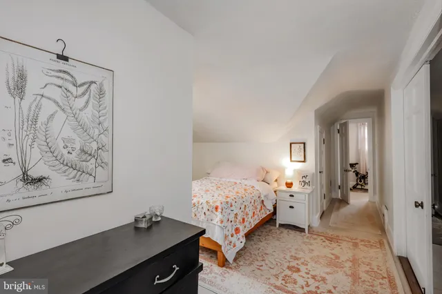 a bedroom with a bed and a lamp on dresser