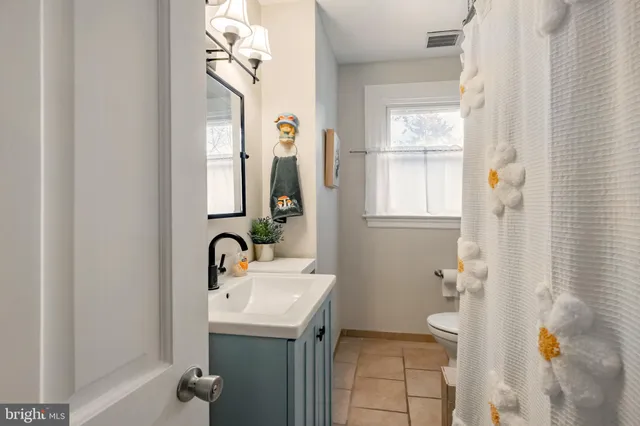 a bathroom with a sink a toilet and mirror