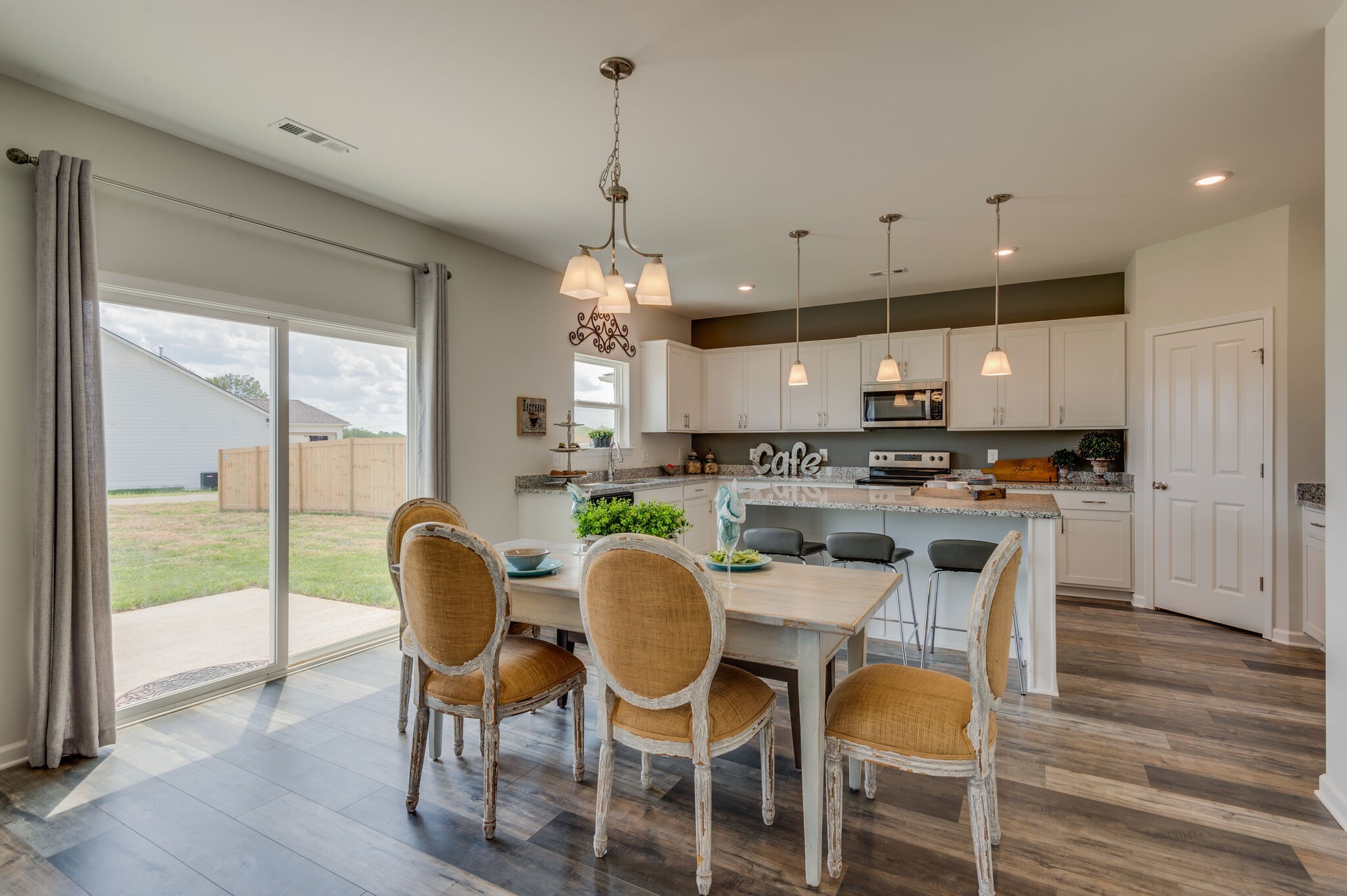611 Castle Road Mount Juliet, TN 37122 - Photo 8 of 30 a kitchen with kitchen island granite countertop a dining table chairs and white cabinets