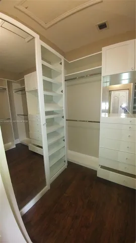 a view of walk in closet with empty racks