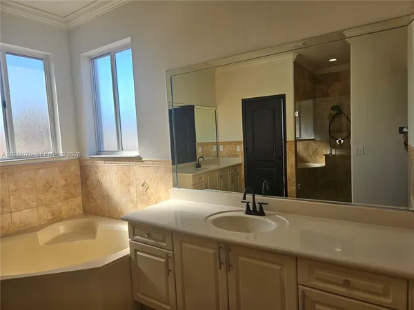a bathroom with a double vanity sink a mirror and a bathtub