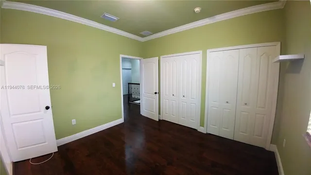 a view of an empty room with closet and a window