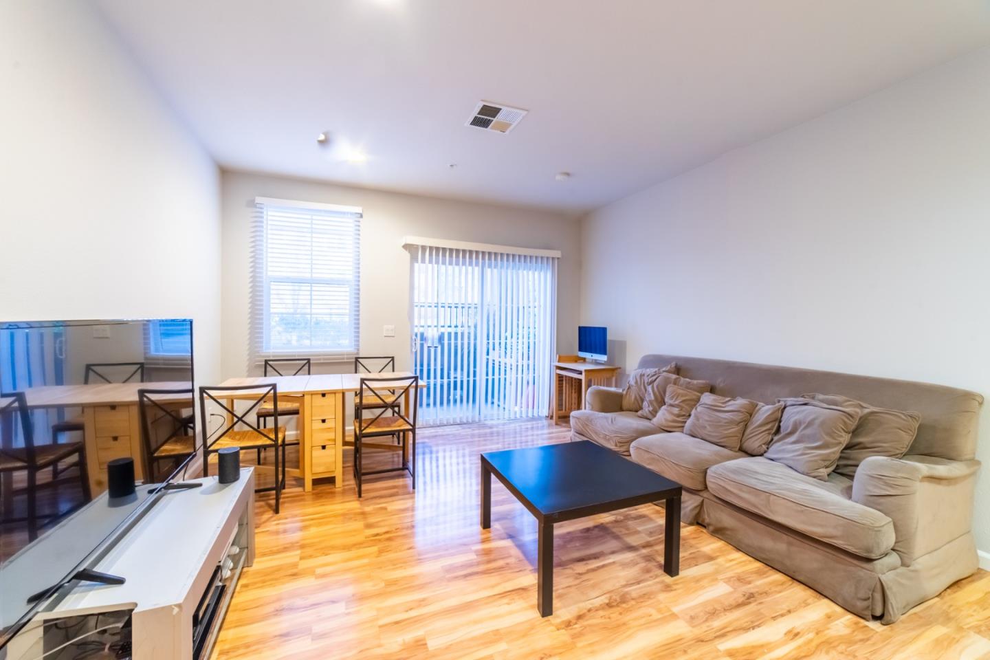 88 North Jackson Avenue, Unit 127 San Jose, CA 95116 - Photo 2 of 10 a living room with furniture and a dining table with wooden floor